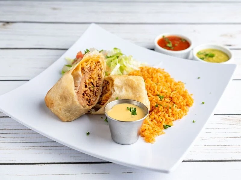 Beef Chimichanga Plate - Deep-fried burrito filled with seasoned beef, topped with cheese sauce