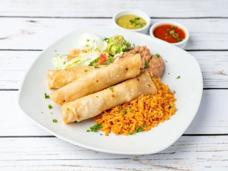 Chicken Flautas Plate - Crispy rolled tortillas filled with chicken, served with guacamole and sour cream